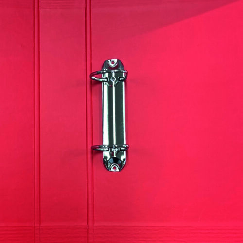 A close-up of a red binder with a metal ring mechanism in the center.