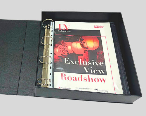 A black ring binder with printed materials titled "Exclusive View Roadshow" resting inside a black presentation box.