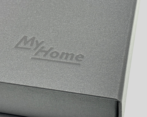 Close-up of a gray book cover with the embossed title "My Home" in a serif font.