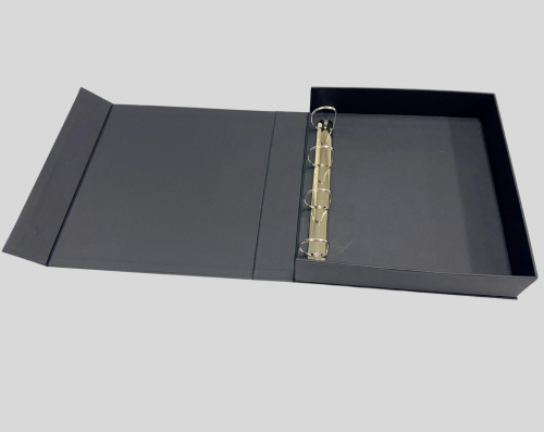 A black binder with a three-ring mechanism, lying open on a flat surface.