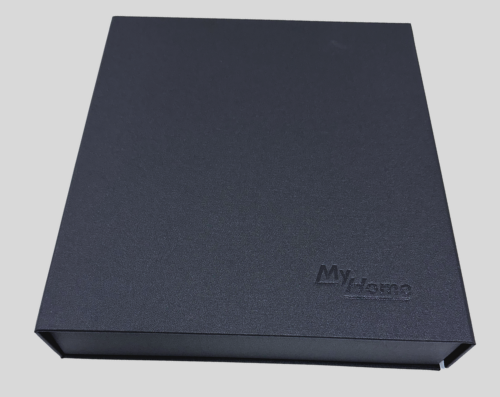 Black rectangular box with the text "MyHome" embossed on it, positioned on a white surface with a slight shadow cast behind it.
